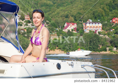 Young woman sunbathing on cutter on river 8431962