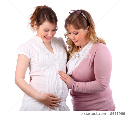 Pregnant woman in white and her girlfriend touching her stomach 8431966