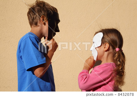 Girl and boy wear black and white masks and look at each other o 8432078
