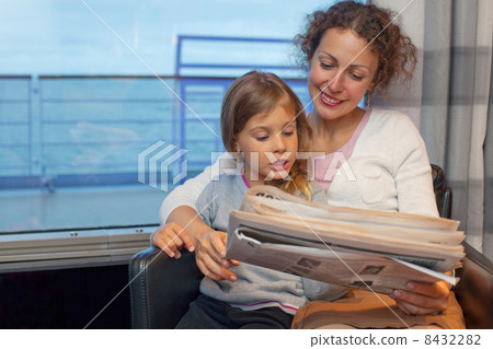 Mother daughter reading newspaper in cabin of large passenger ship, focus on daughter Mother daughter reading newspaper in cabin of large passenger ship, focus on daughter 8432282