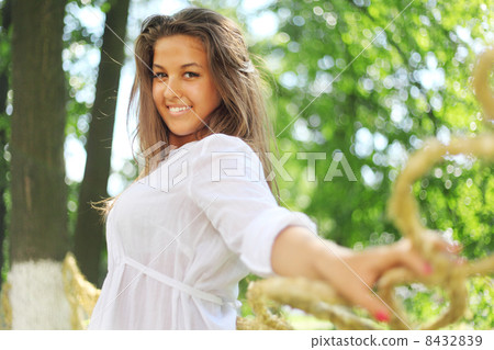 Beautiful girl pose, leaned on braided straw 8432839