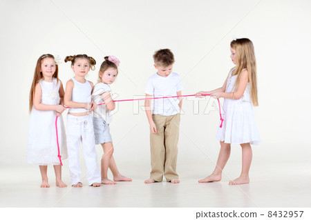 Four little girls in white clothes draw over pink rope and boy l 8432957