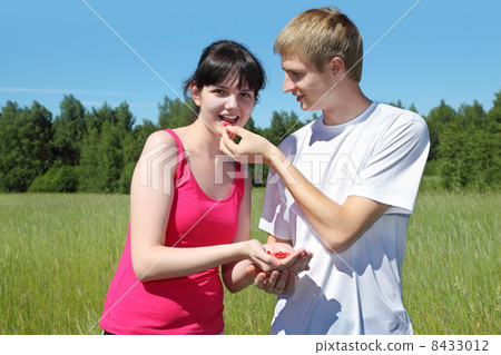 Husband feeds wife berry from hand 8433012