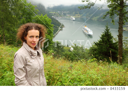 Woman tourist at background of two passenger liners in fiord of 8433159