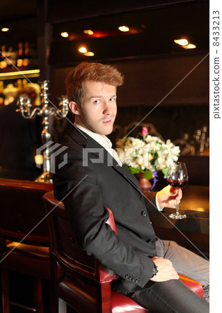 smirk young man in a black suit holding a glass of wine smirk young man in a black suit holding a glass of wine 8433213