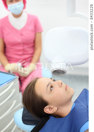 Dentist prepares to make jaw x-ray image for little girl in dent Dentist prepares to make jaw x-ray image for little girl in dent 8433226