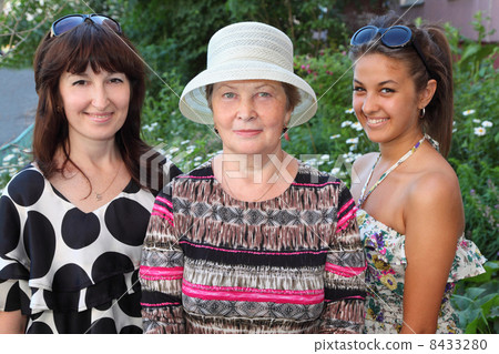 Grandmother, mother, daughter near cottage 8433280