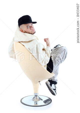 Rapper in yellow jacket sits on yellow chair with his back to ca 8433407