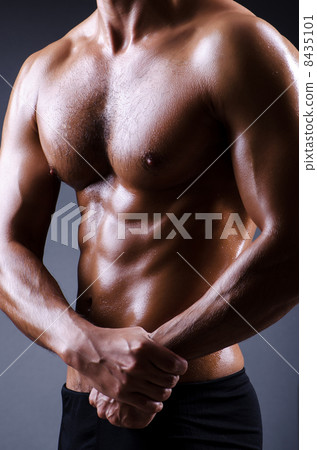 Muscular man in dark studio Muscular man in dark studio 8435101