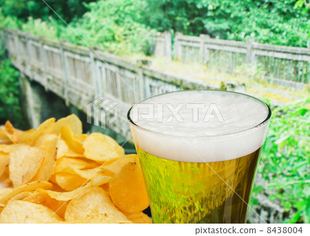 glass of beer and potato chips in a landscape glass of beer and potato chips in a landscape 8438004