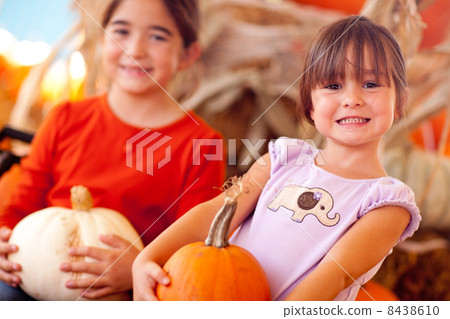Cute Little Girls Holding Their Pumpkins At A Pumpkin Patch 8438610