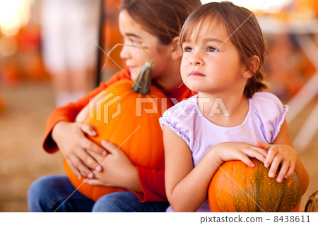 Cute Little Girls Holding Their Pumpkins At A Pumpkin Patch 8438611