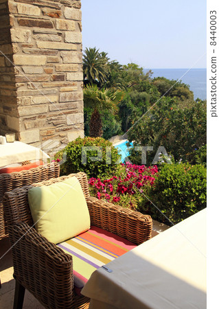 wicker armchair on terrace overlooking the sea and garden (Greec 8440003