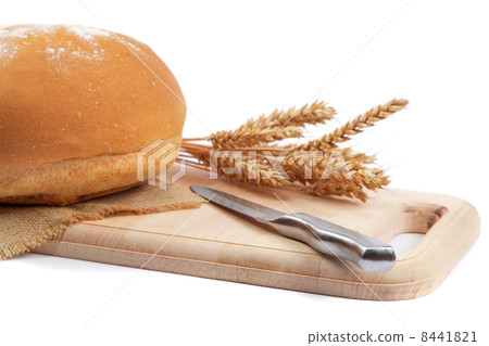 Fresh bread with ears and a knife of wheat on the wooden cutting Fresh bread with ears and a knife of wheat on the wooden cutting 8441821
