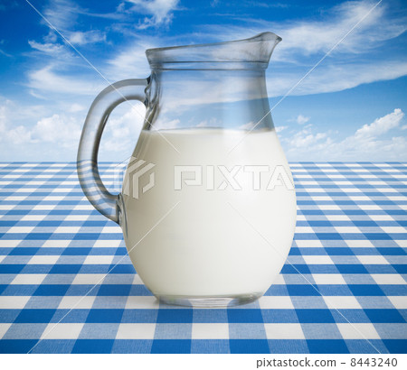 Milk jug on blue tablecloth Milk jug on blue tablecloth 8443240