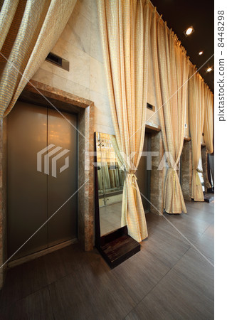 Several doors of lifts and long yellow curtains in empty hallway Several doors of lifts and long yellow curtains in empty hallway 8448298