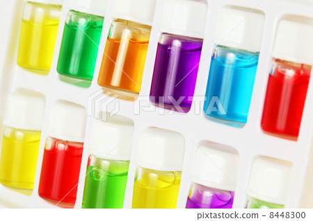 Twelve bottles of different colored aromatic oils in white plast Twelve bottles of different colored aromatic oils in white plast 8448300