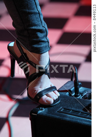 Part of leg of woman stepped on amplifier in studio with checker Part of leg of woman stepped on amplifier in studio with checker 8449113