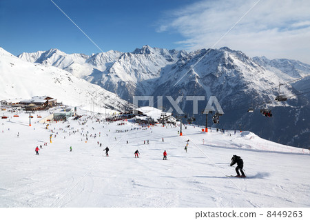 Cable car, buildings in mountains. Many skiers ride in Alps at s 8449263