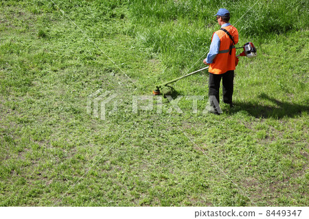 Man lawn-mower with chopper trimer moving grass at sunny summer Man lawn-mower with chopper trimer moving grass at sunny summer 8449347