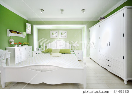 Stylish green bedroom with big white bed, wardrobe and chest of Stylish green bedroom with big white bed, wardrobe and chest of 8449380