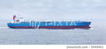 Large cargo ship with red and blue boards floats in open ocean Large cargo ship with red and blue boards floats in open ocean 8449401