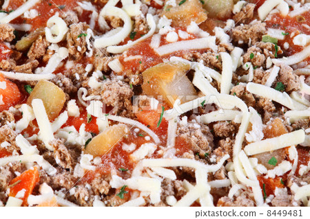 Close-up of individual frozen pizza with meat, cheese, tomatoes. 8449481