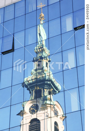 Stiftskirche in reflections of high glass building in Vienna, Austria 8449980