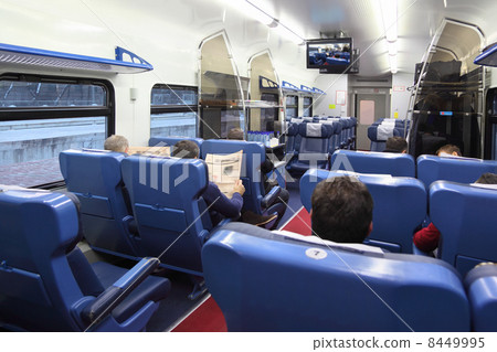 Back of passengers sitting in soft blue chairs in train carriage Back of passengers sitting in soft blue chairs in train carriage 8449995