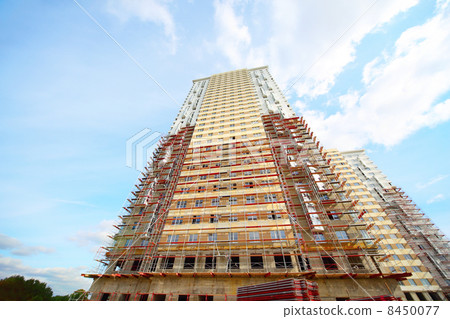 MOSCOW - SEP 27: Tubes, tree near construction of high building on Sep 27, 2011 in Moscow, Russia. Residential complex Elk Island has a three-level underground parking for 1,700 cars with three-point car wash. 8450077