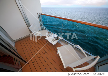 balcony with chairs table bottle glass binoculars on ship with view on sea 8450698