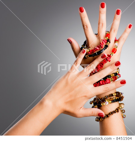Closeup photo of a female hands with red nails Closeup photo of a female hands with red nails 8451504
