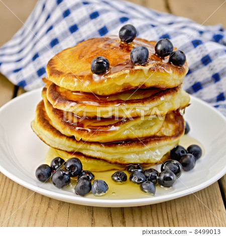 Flapjacks with blueberries and honey on the board Flapjacks with blueberries and honey on the board 8499013