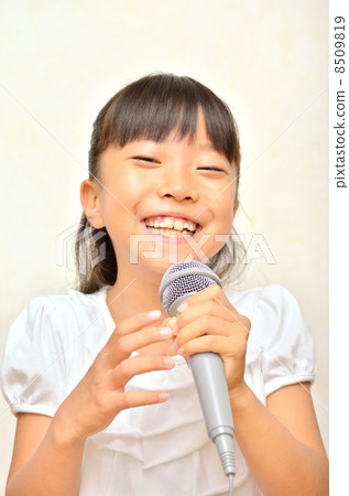 一個女孩用麥克風唱歌 8509819