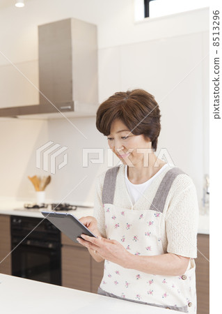 一個女人在廚房裡搜索食譜 一個女人在廚房裡搜索食譜 8513296