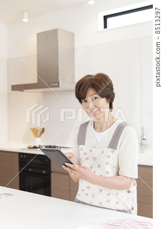一個女人在廚房裡搜索食譜 一個女人在廚房裡搜索食譜 8513297