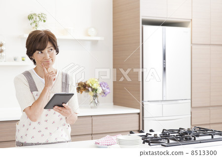 一個女人在廚房裡搜索食譜 一個女人在廚房裡搜索食譜 8513300
