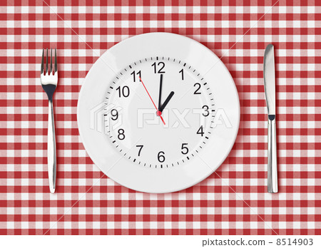 Knife, white plate with clock face and fork on red picnic table 8514903