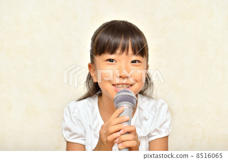 一個女孩用麥克風唱歌 8516065