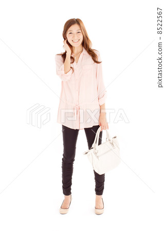 一個時髦的日本女孩,在撫摸她的頭髮時表現出漂亮的微笑 一個時髦的日本女孩,在撫摸她的頭髮時表現出漂亮的微笑 8522567