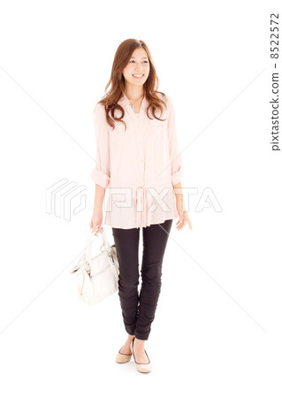 30多歲的女性時髦的走路,同時側身看著一個白色的包 30多歲的女性時髦的走路,同時側身看著一個白色的包 8522572