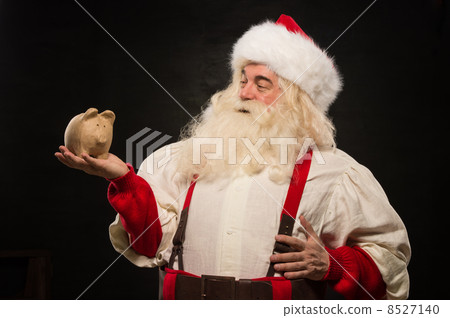 Santa Claus holding piggy bank moneybox Santa Claus holding piggy bank moneybox 8527140