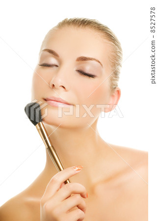 Beautiful young woman with a make-up brush. Isolated on white ba 8527578