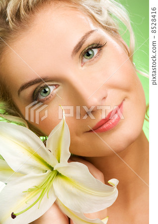 Beautiful young woman with lily flower. Close-up portrait 8528416