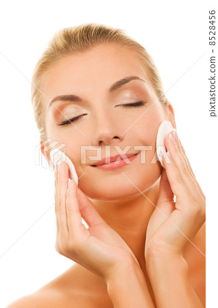 Beautiful young woman removing cosmetics with cleansing pad Beautiful young woman removing cosmetics with cleansing pad 8528456