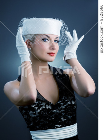 Beautiful young woman in white hat with net veil. Retro portrait 8528666