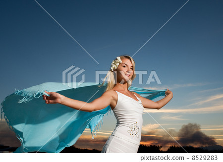 Beautiful young woman with a shawl relaxing outdoors 8529283