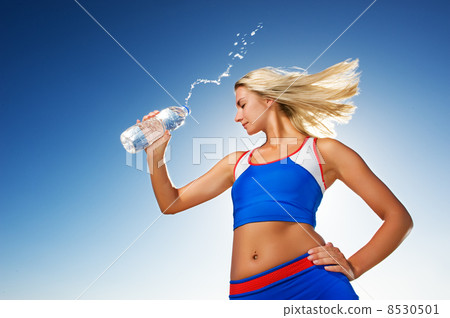 Young woman drinking water after fitness exercise Young woman drinking water after fitness exercise 8530501