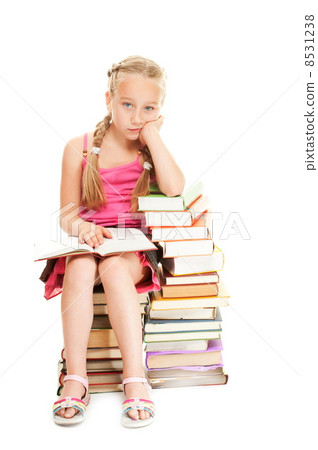 Little schoolgirl sitting on a stack of books.... 8531238
