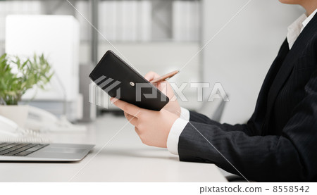Business woman who writes in the notebook 8558542